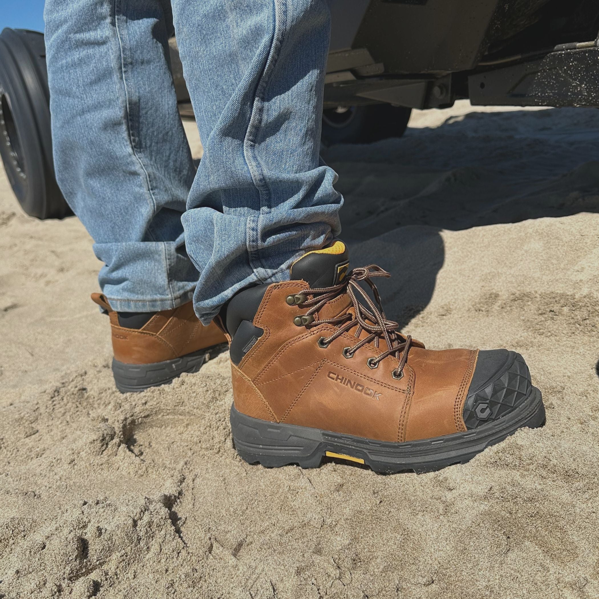 A guy in Maverick 6” Comp Toe Men’s Waterproof Work Boots in wheat stands firmly in the sand. These rugged boots, featuring reinforced toes and solid soles, are built to tackle anything the job or the outdoors throws your way.