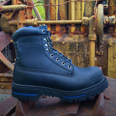 Close-up of the Tarantula 8" Steel Toe Men’s Waterproof Work Boot in Black, set against an industrial background. The boot features a rugged design with a reinforced steel toe, durable leather, and a sturdy outsole, built for tough work environments.